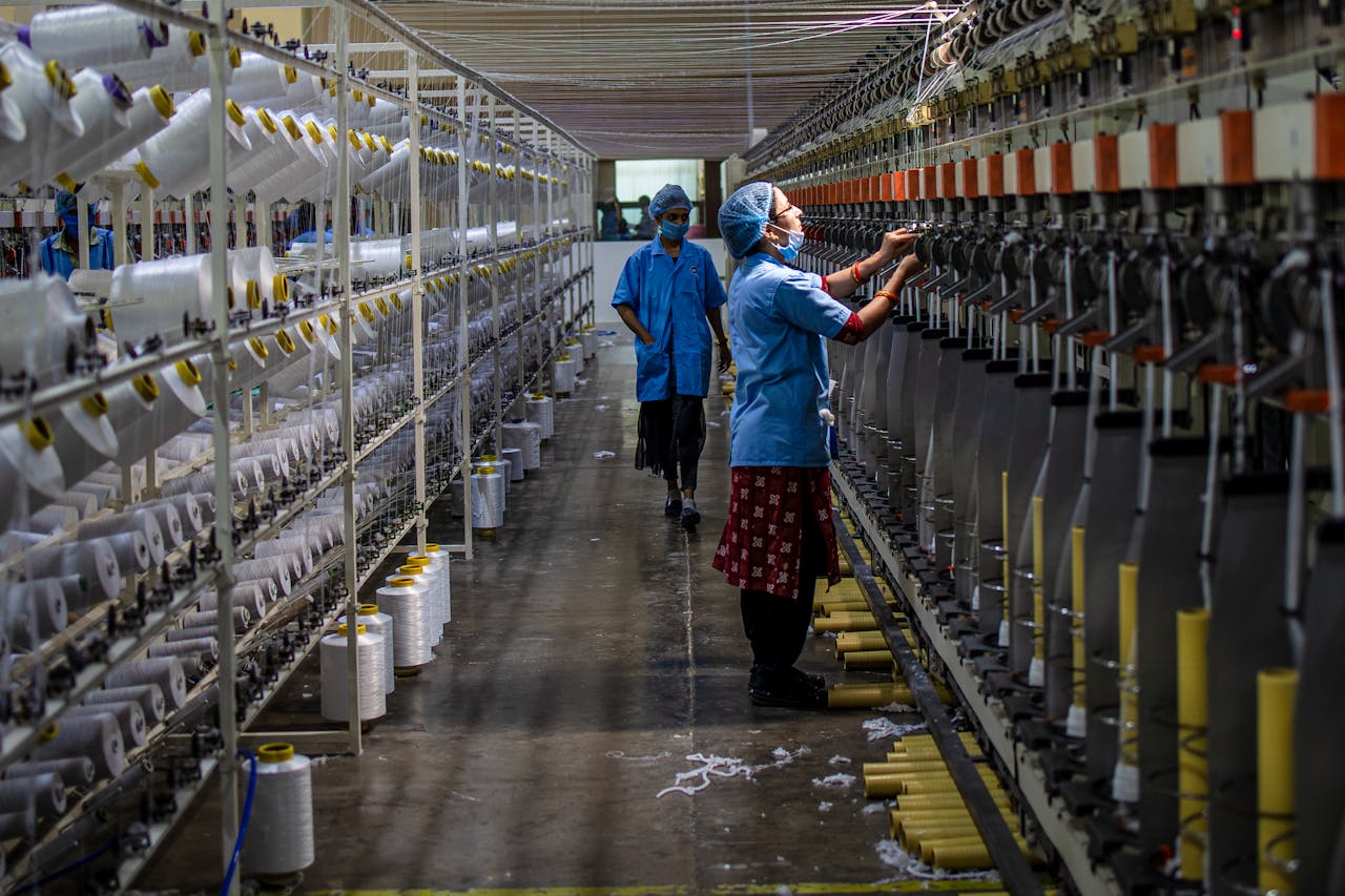Workers operating machinery in a textile factory, showcasing industrial processes.